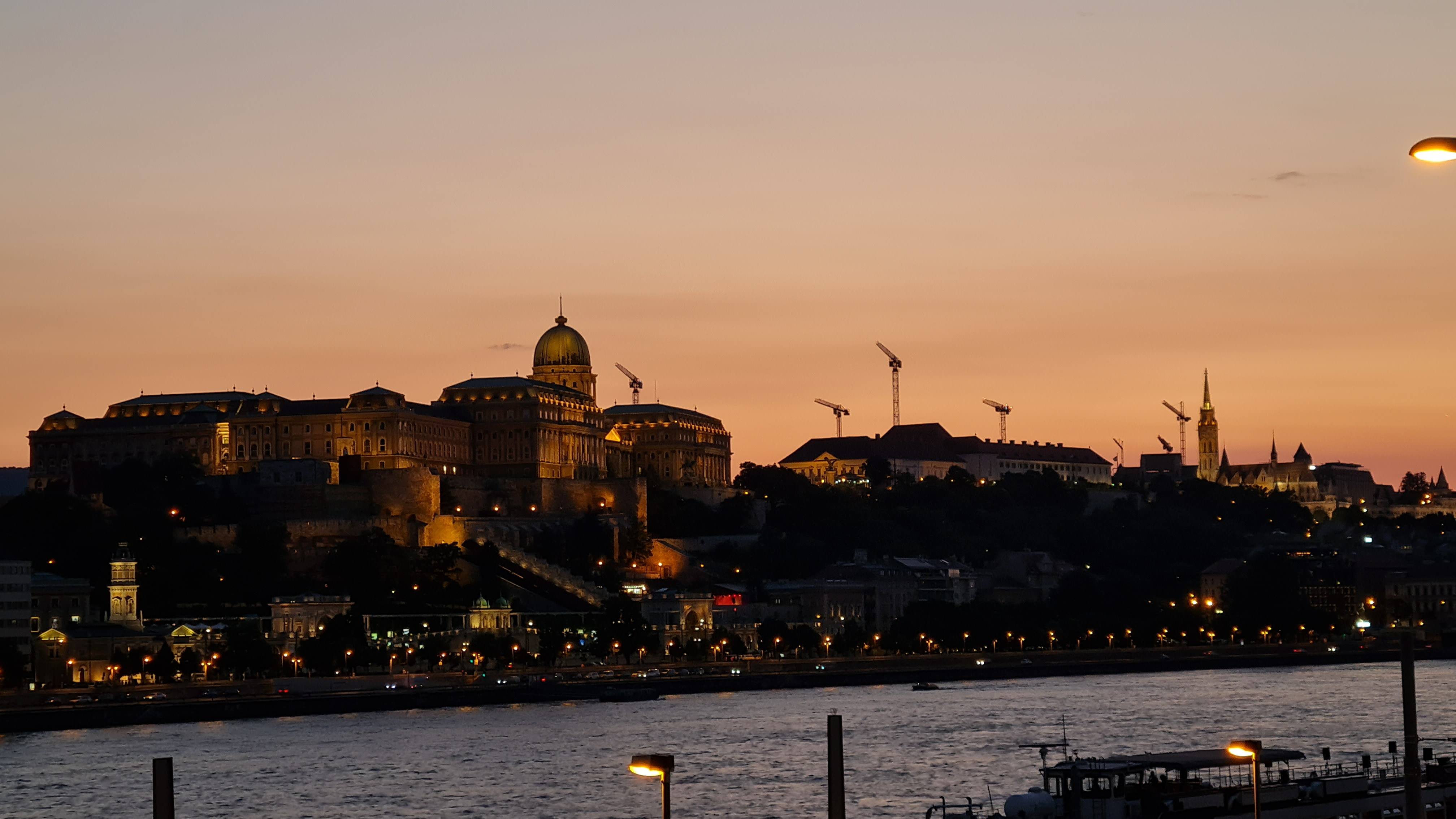 Buda Castle illuminated at dusk above the Danube, Budapest