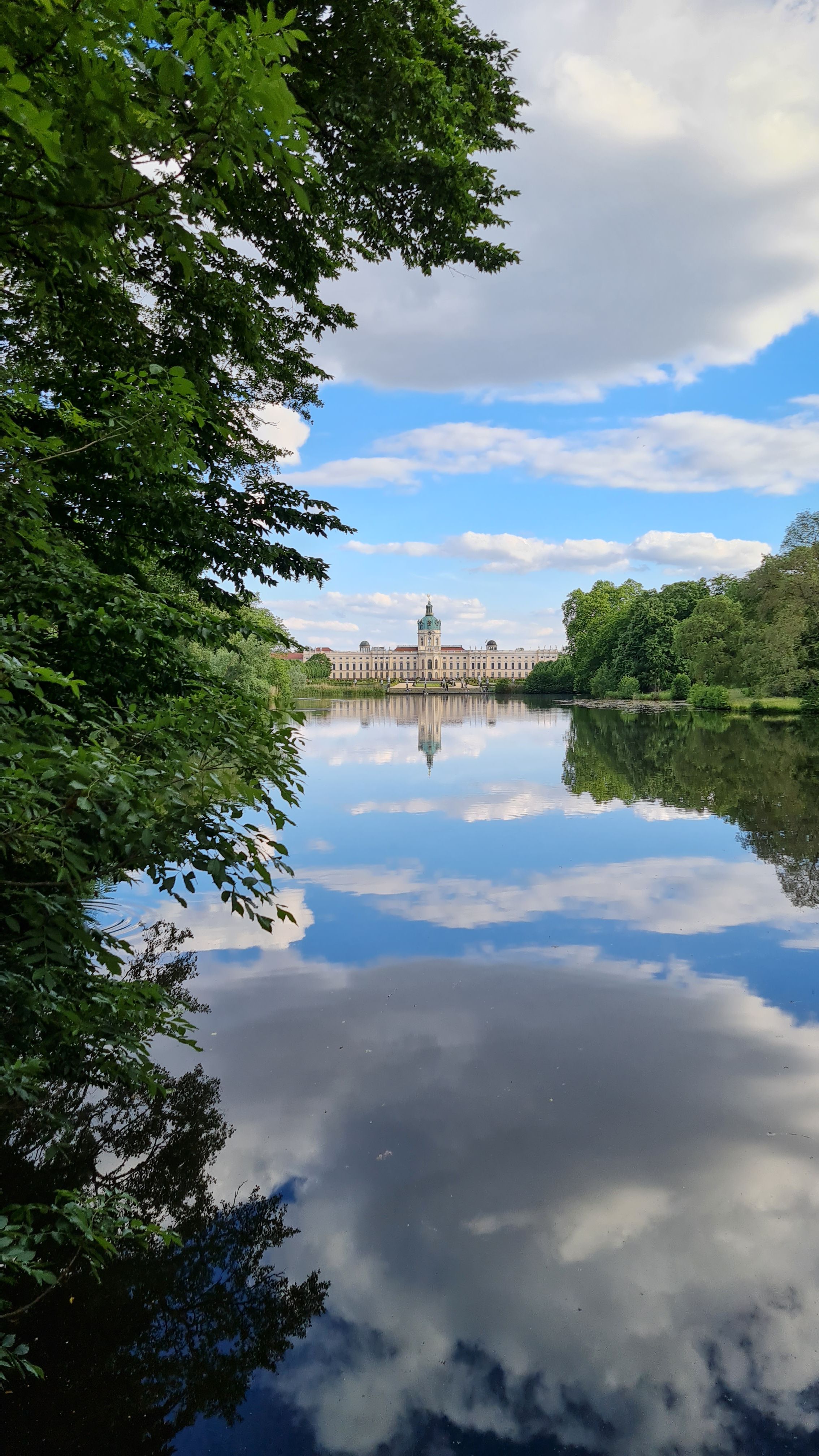 Charlottenburg Palace reflected in the lake, framed by trees, Berlin
